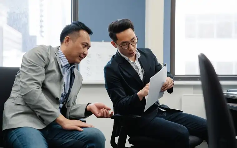 사무실에서 서류를 보며 상담하는 두 사람