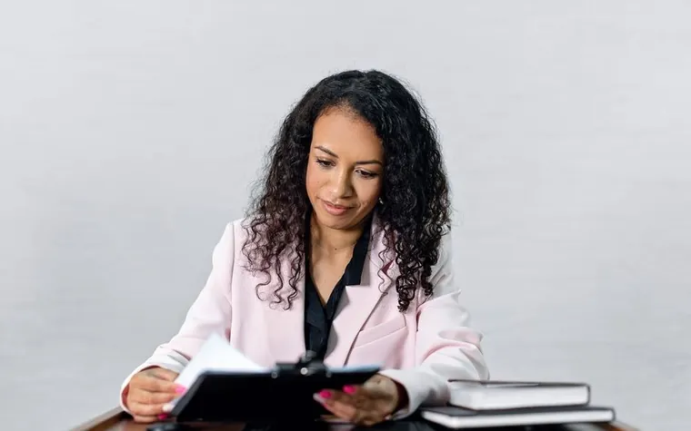 An office worker reviewing a folder of documents to confirm an application