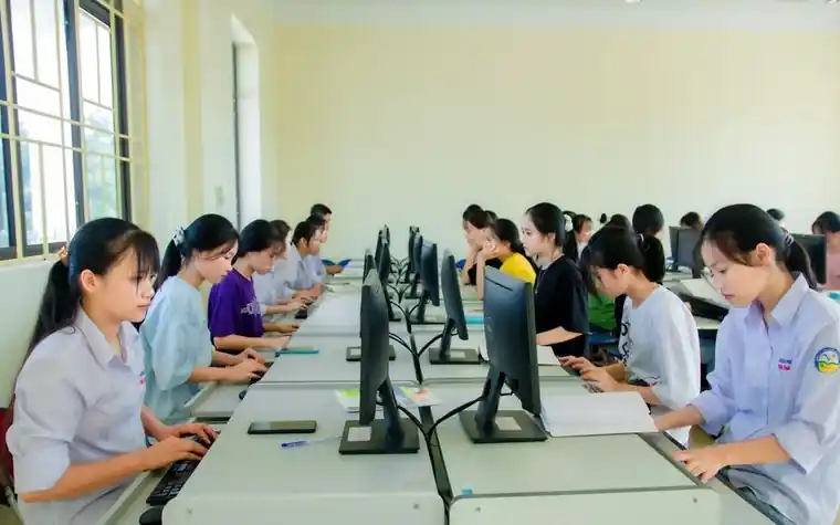 컴퓨터가 여러 대 놓인 교실에서 여러 사람이 나란히 앉아 직업훈련 수업을 듣는 모습