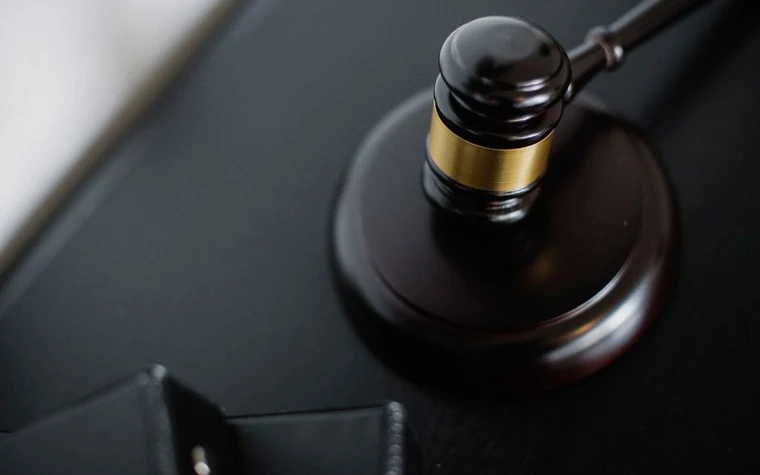 A wooden gavel viewed from above beside case folders