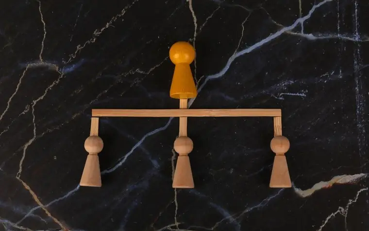 Wooden figures balanced like a scale