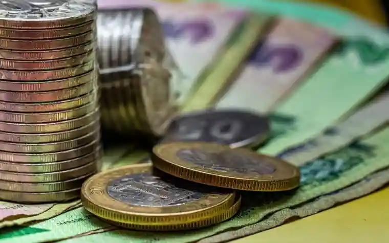 Several coins and banknotes stacked on top of each other