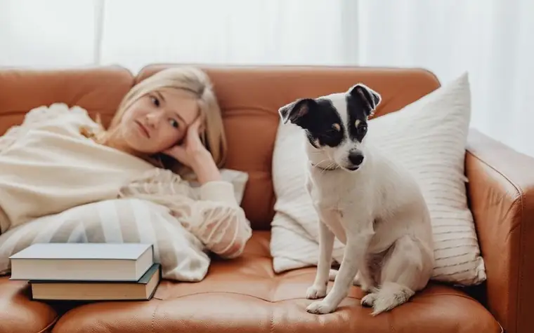 Woman relaxing with her dog on a cozy sofa