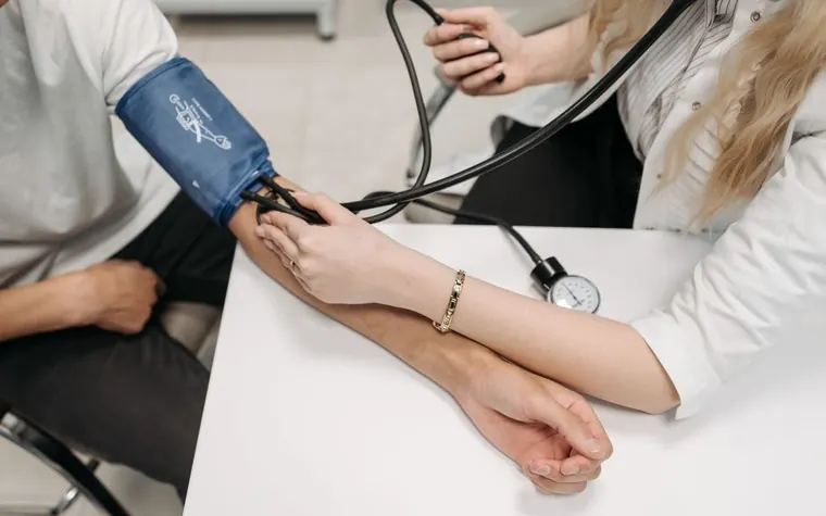 혈압계 커프를 팔에 감고 혈압을 재는 모습