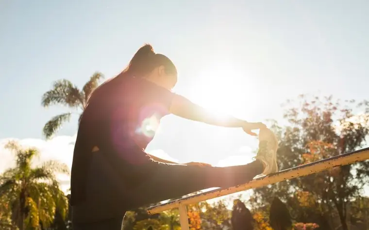 Woman stretching in sunlight, outdoor activity for vitamin D