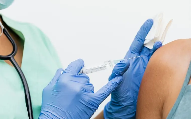 A nurse giving an injection to an older adult's arm