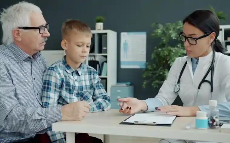 A doctor explaining medical information to an older patient and a child in a consultation room