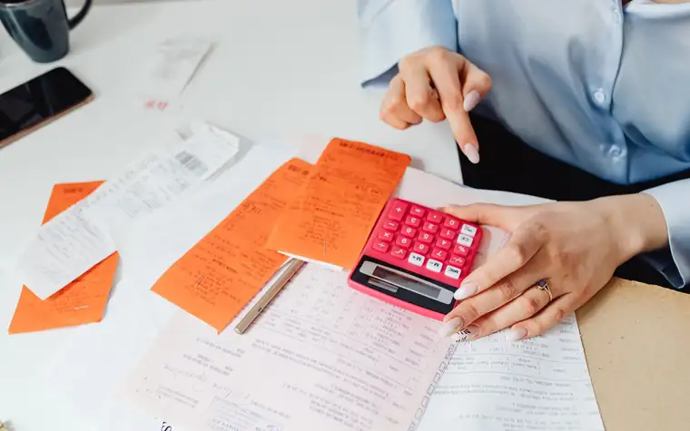 Settling costs with receipts and a calculator on a desk
