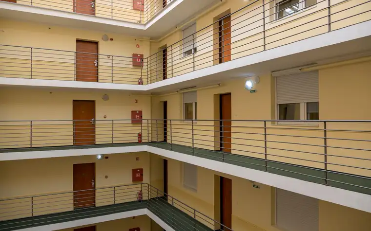 A multi-storey residential corridor with railings