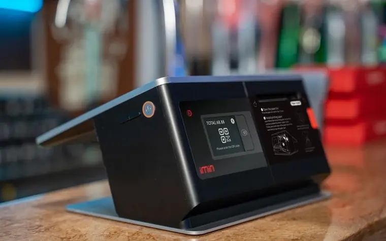 A touchscreen payment terminal on a store counter