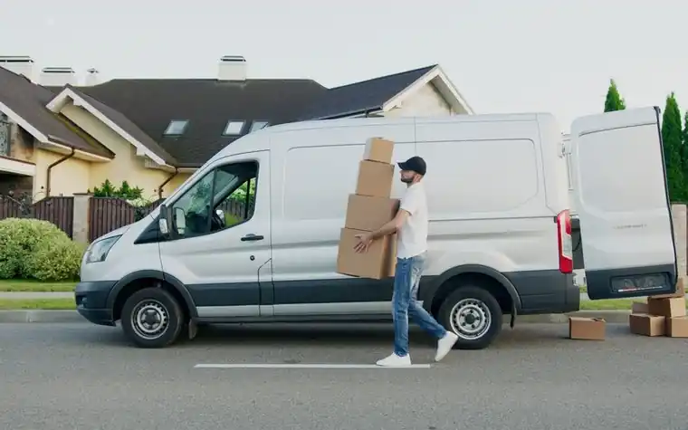 Movers carrying boxes in front of a moving truck