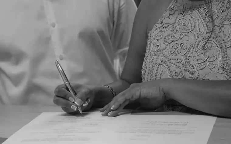 A man and a woman signing a document at a table
