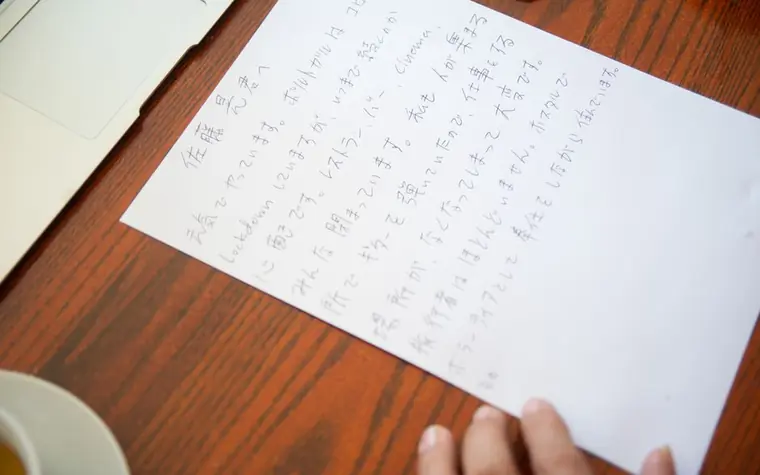 나무 책상 위에 손글씨로 쓴 편지지