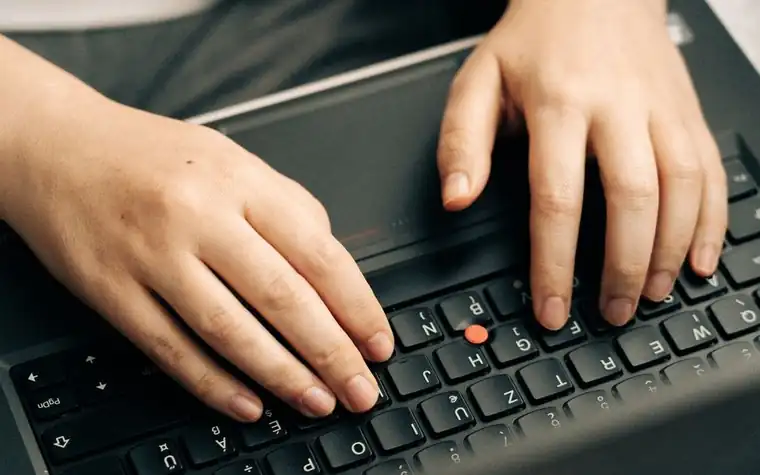노트북 자판을 클로즈업으로 두드리는 손