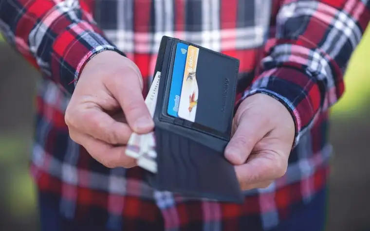 A hand taking a card out of a wallet