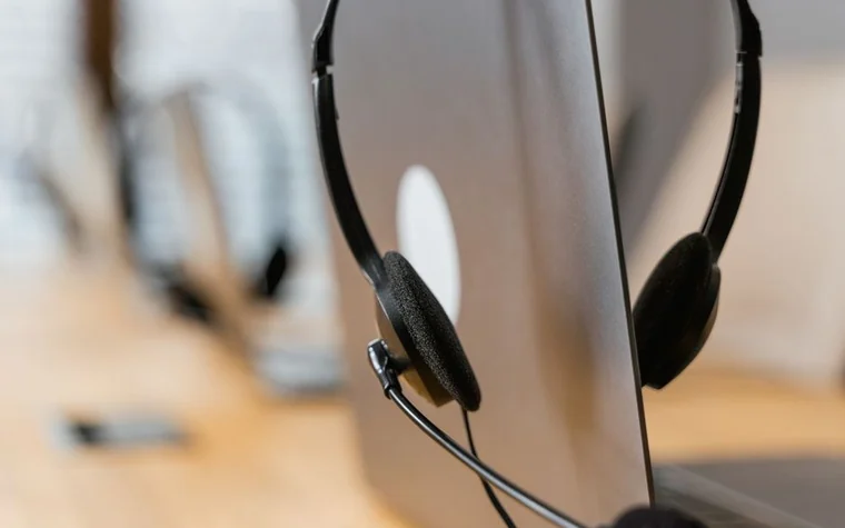 A customer-service headset resting in front of a laptop